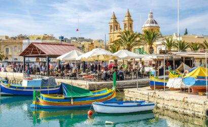 blue and yellow boat on water near brown concrete building during daytime