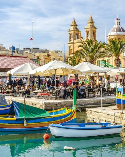 blue and yellow boat on water near brown concrete building during daytime